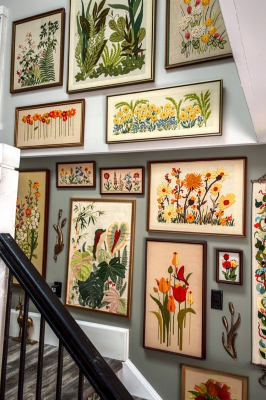Colorful botanical staircase gallery wall with framed floral and plant artwork in vintage-style frames