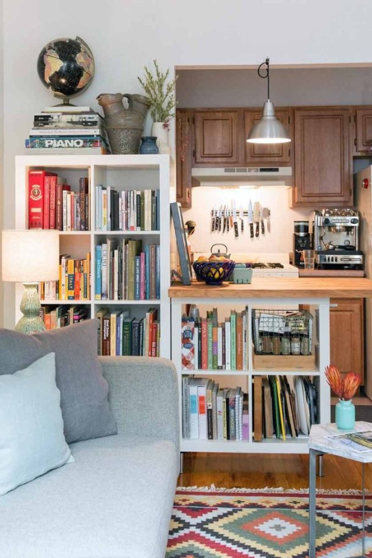 Compact studio apartment layout with open kitchen and integrated bookshelves, combining cozy living and functional storage for small space efficiency in 2025