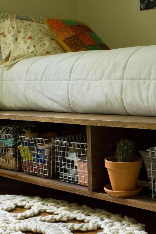 Under-bed storage with baskets and bins maximizing space in a studio apartment bedroom