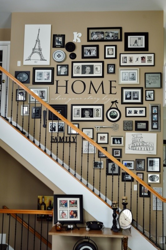Large staircase gallery wall featuring family photos, typography, artwork, and mixed black frames