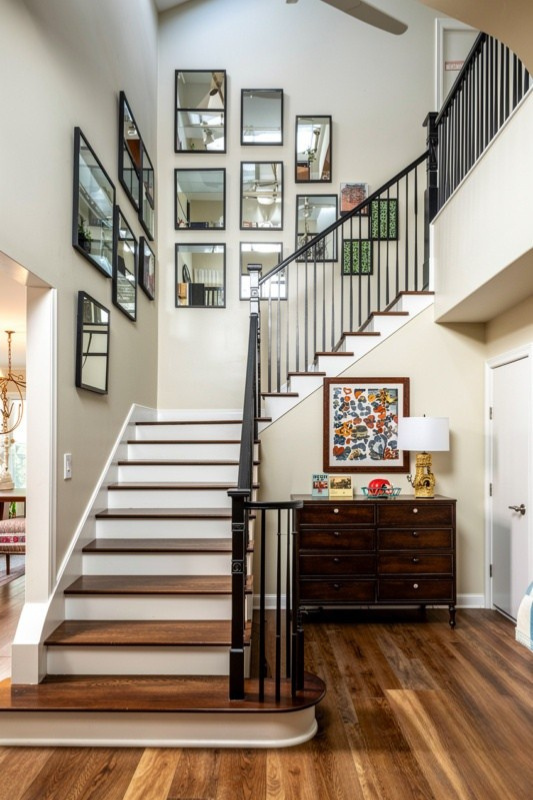 Modern staircase wall decorated with a collection of rectangular mirrors above wood stairs