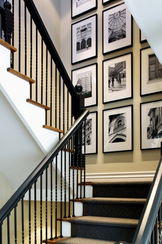 Modern staircase gallery wall with large black frames and black-and-white architectural photography