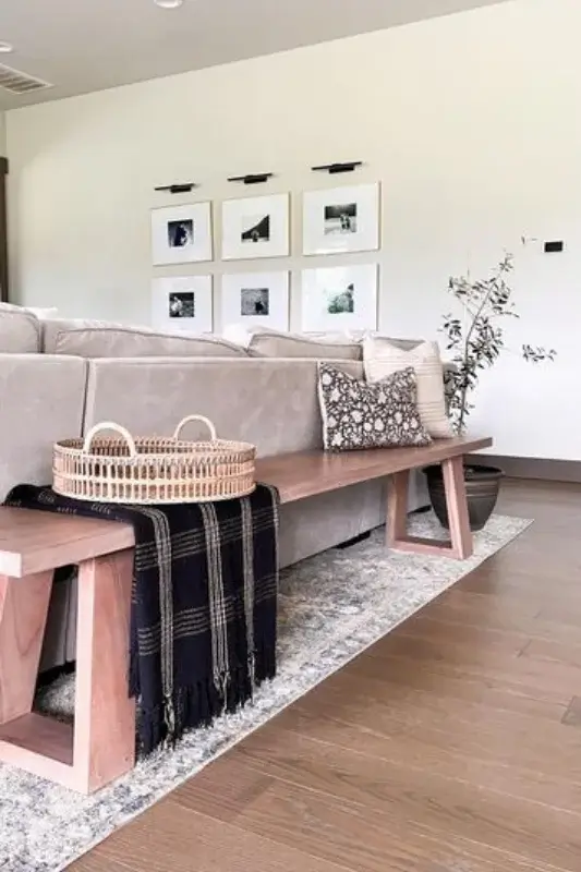 Wood picture ledge shelf behind sofa styled with framed artwork and prints for simple and space saving behind the couch wall decor