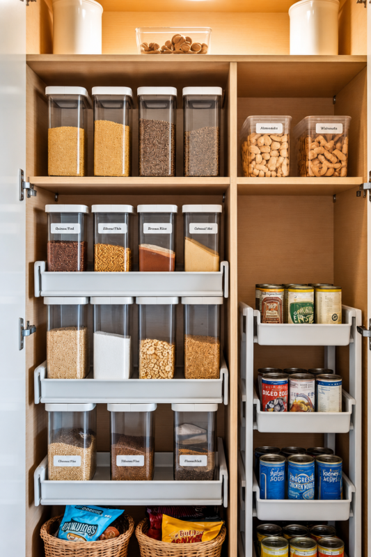 Over-the-door pantry organizer holding sauces, jars, canned foods, drinks and pantry essentials.