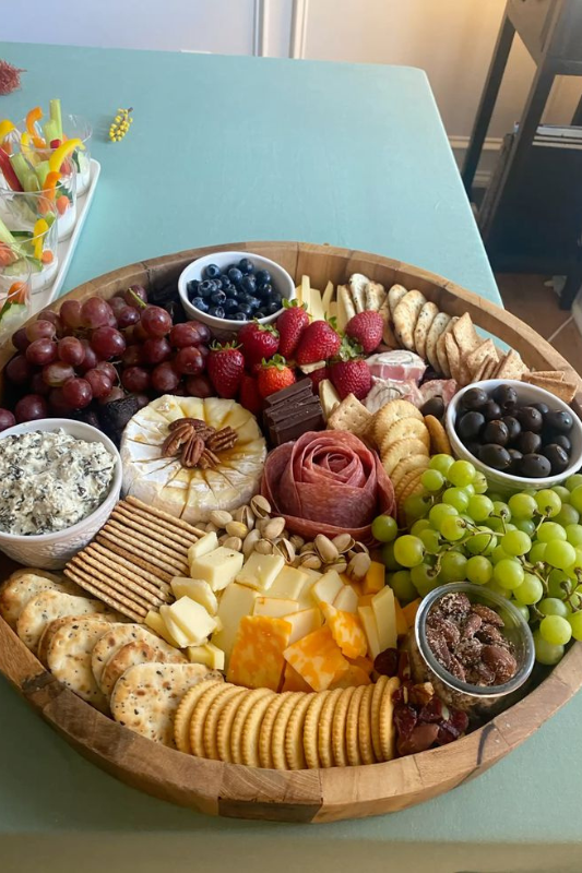 dessert charcuterie board with strawberries blueberries macarons chocolate bars and cookies