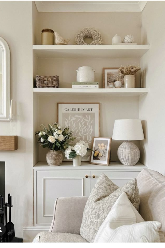 Neutral built-in shelves styled with rounded vessels, muted tones, and soft textures for a calm, cohesive farmhouse look.