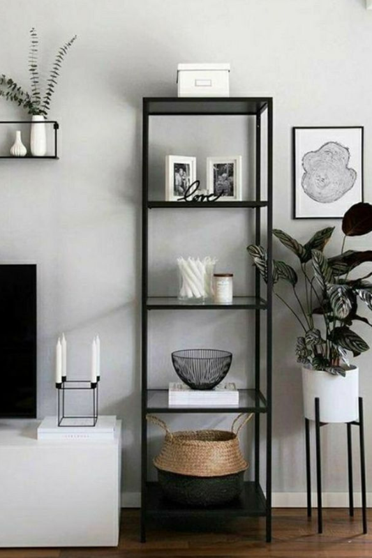 Narrow black shelving unit with neutral decor, white baskets, and minimal styling for a modern or Scandinavian living room.