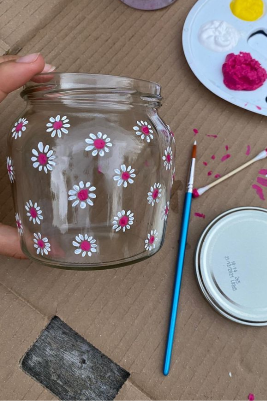 Painted glass jar with floral designs used as a candle holder for an easy summer DIY craft