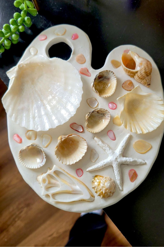 Seashell resin art board with shells and beach elements sealed in clear resin for summer decor