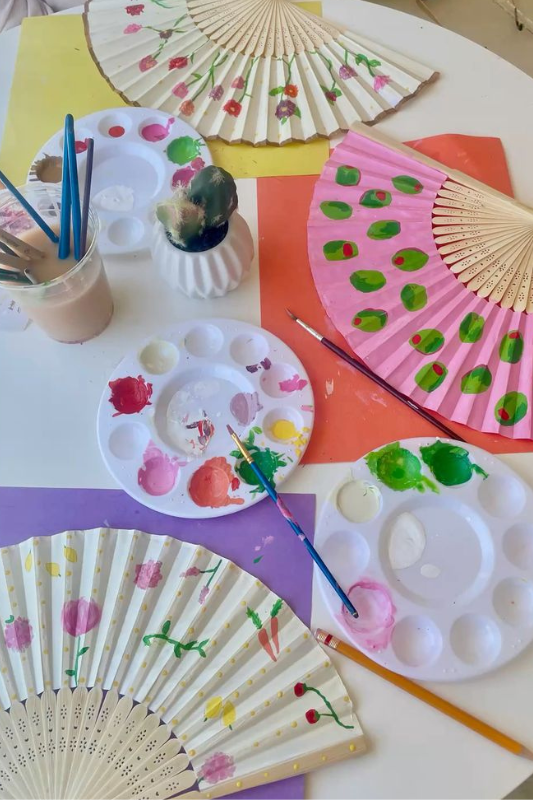 Hand painted paper fans with colorful patterns as an easy summer craft for hot days