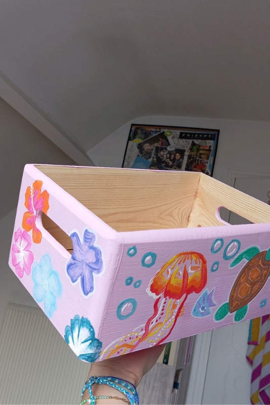 Hand painted wooden storage box with sea inspired designs used for organizing summer items