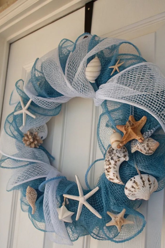 Blue and white coastal wreath decorated with mesh ribbon and seashells for summer front door decor