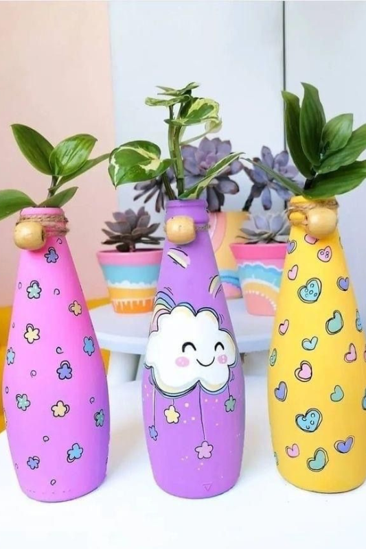 Painted glass bottle planters holding green plants for a bright and easy summer DIY decor idea