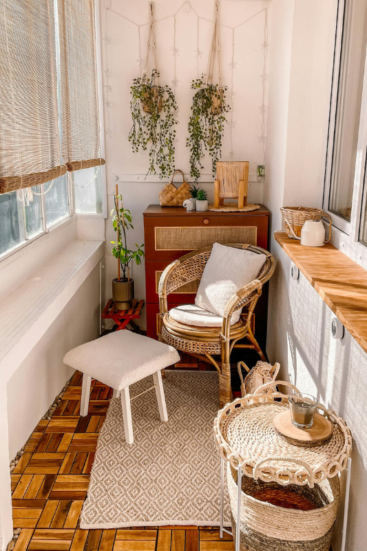 Enclosed balcony transformed into a boho sitting nook with rattan furniture and soft textures