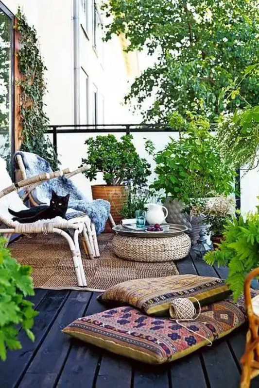 Compact balcony with colorful café chairs, plants, and textiles for a curated yet relaxed look