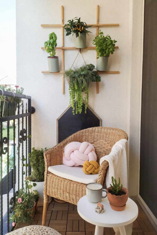Balcony daybed styled with neutral cushions, wall art, and curtains for a hotel inspired space