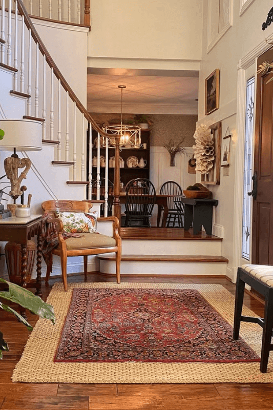 Entryway rug layering with a red vintage runner placed over a natural jute rug