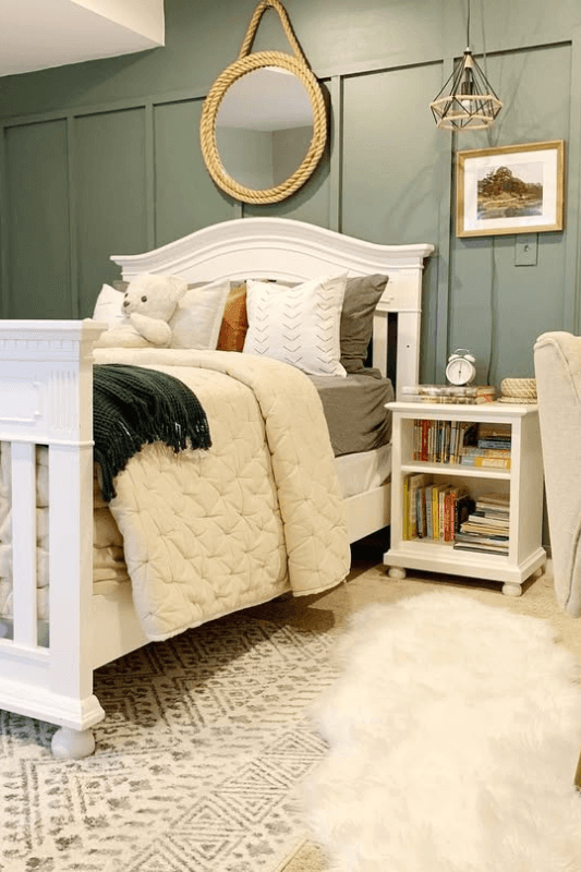 Bedroom with a white faux fur rug layered over a neutral patterned area rug beside the bed