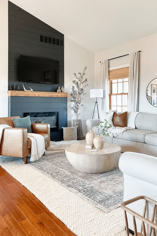Layered rug ideas in a neutral living room with a patterned area rug over a large textured cream rug