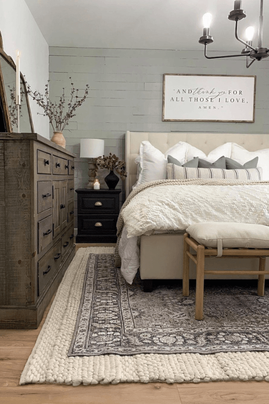 layered rugs in a cozy bedroom with a gray patterned rug over a chunky cream area rug