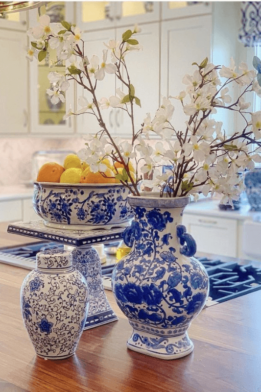 Blue and white ceramic vase with white flowering branches for summer table decor