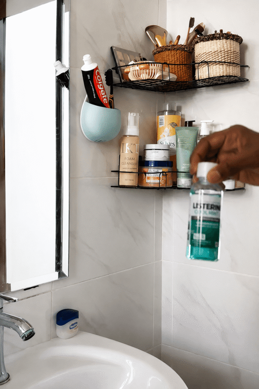 Arranging everyday skincare products on a bathroom wall shelf