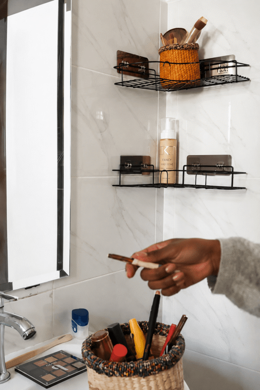 Placing a woven makeup basket on the top bathroom shelf