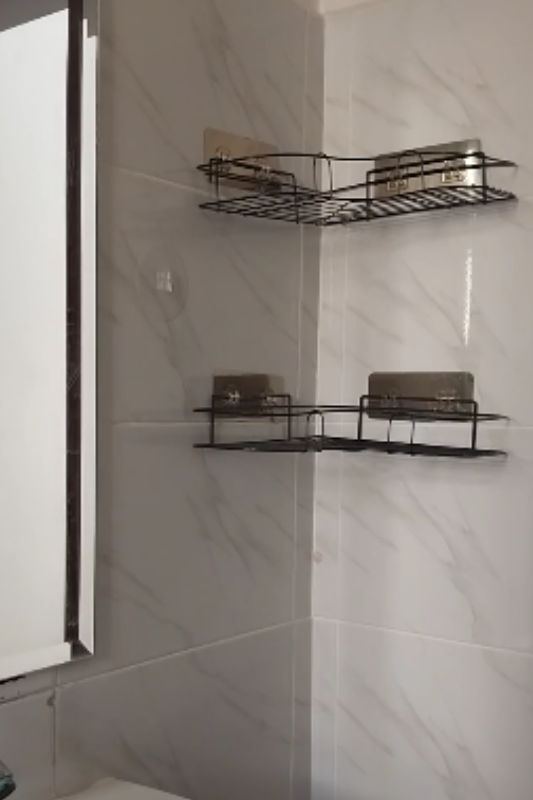 Empty wall-mounted shelves beside a bathroom mirror ready for makeup and skincare organization
