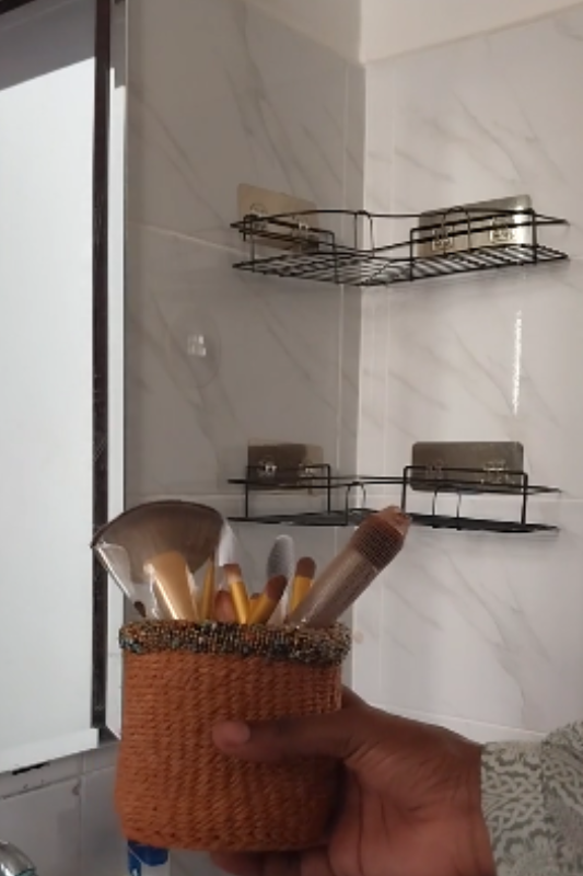 Placing a makeup brush holder on the top wall-mounted bathroom shelf