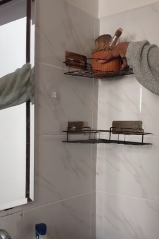 Placing a makeup brush holder on the top wall-mounted bathroom shelf