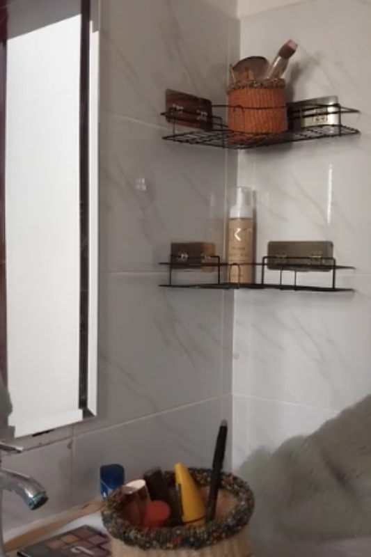 Sorting makeup products in a woven basket during a bathroom shelf organization makeover