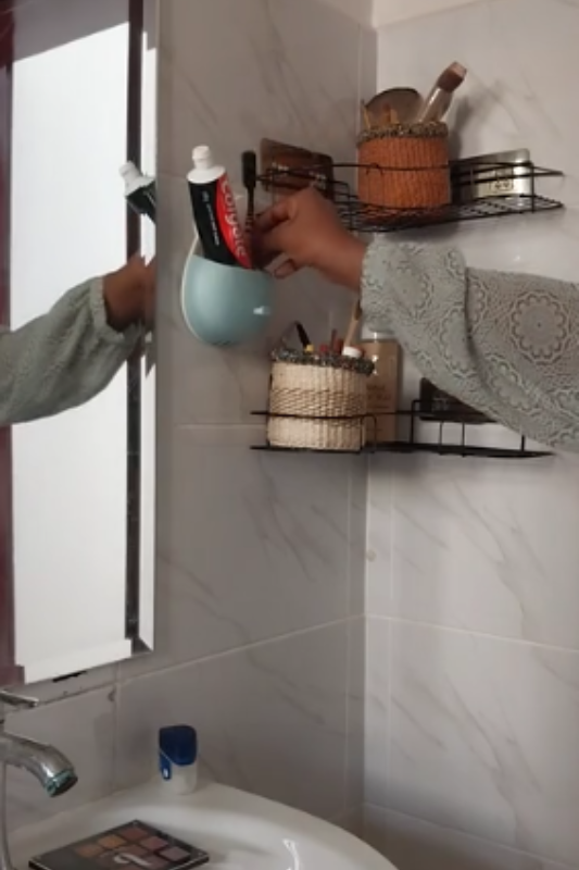 Arranging makeup baskets and everyday essentials on small bathroom wall shelves