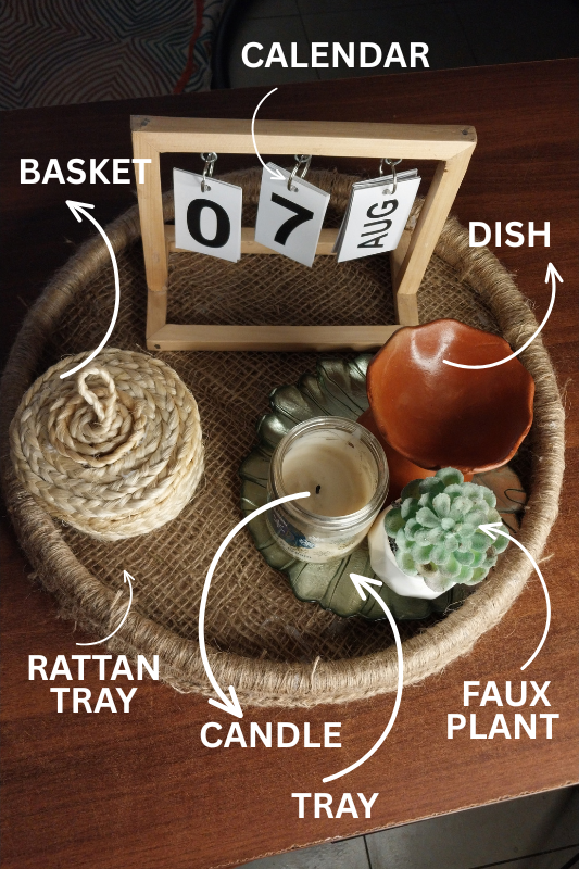Rattan tray styled with calendar plant candle and woven key holder for top of fridge decor