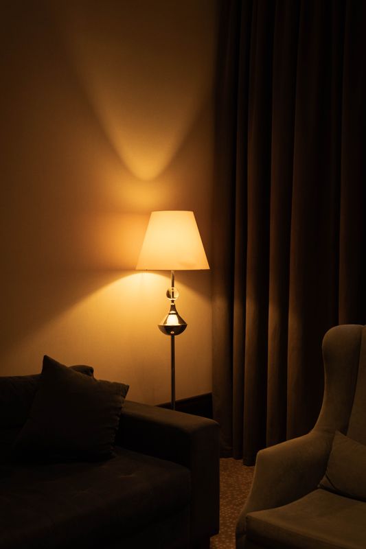 Warm floor lamp creating a soft pool of light between living room seating